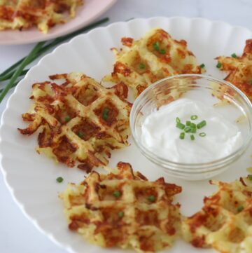Latke waffles on a white plate with sour cream and chive