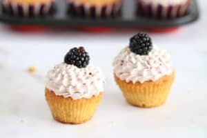 2 blackberry cupcakes on a surface