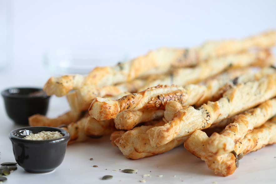 breadsticks on a surface with little bowls of dip