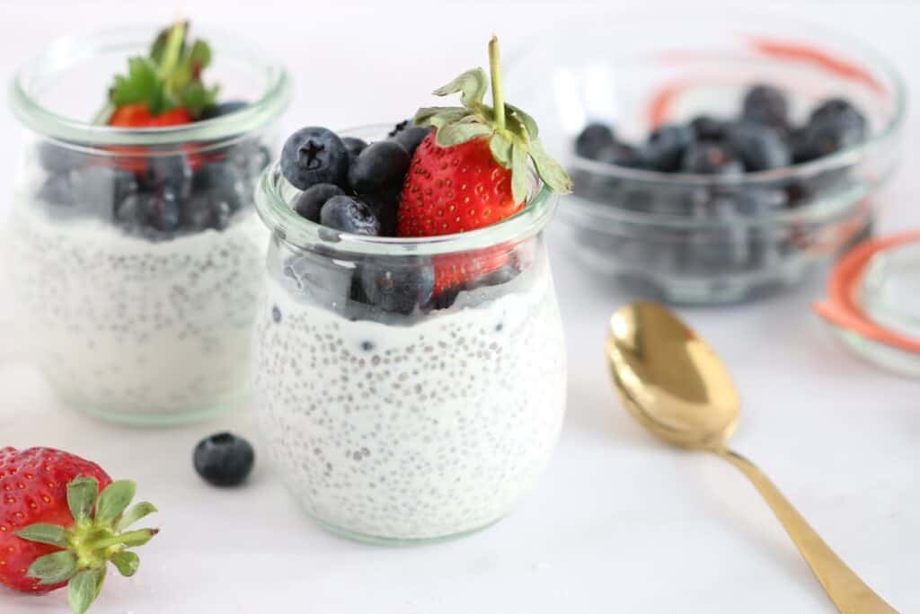 chia pudding in small jars with berries on top