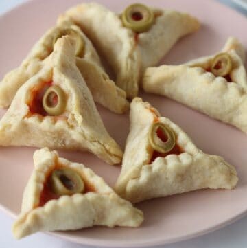 Pizza Hamantaschen cookies on a pink plate