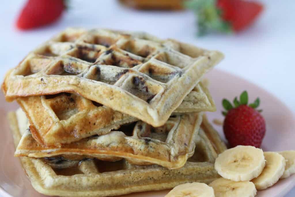 Chocolate Chip Waffles on a plate with banana and strawberries